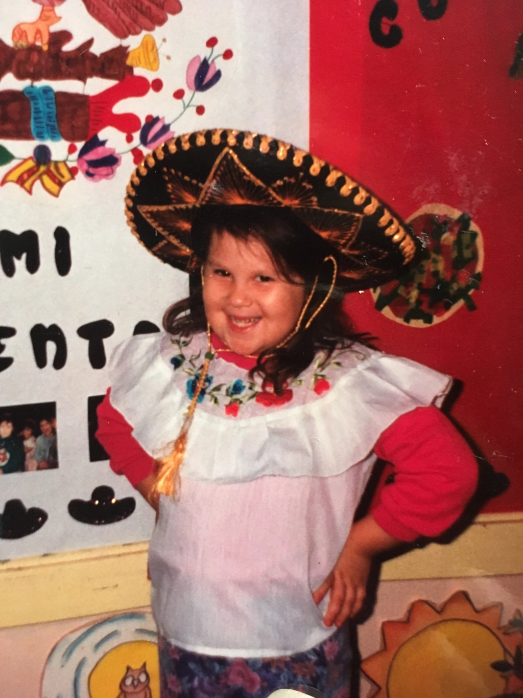 A childhood photograph of Nohemi in a sombrero and embroidered blouse at a school celebration